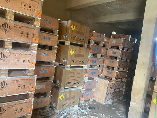 Pallets of wooden crates labeled lithium iron phosphate battery UN 3480 stacked inside a warehouse